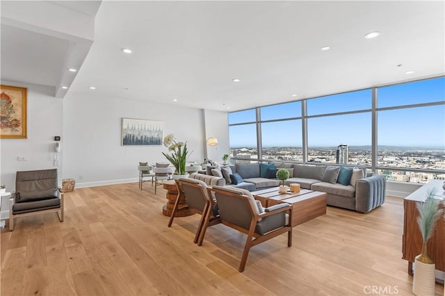 living room featuring expansive windows and light hardwood / wood-style flooring