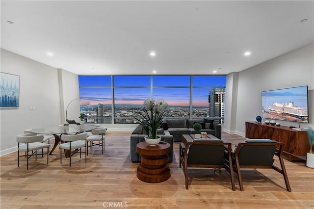 living room with floor to ceiling windows and light hardwood / wood-style floors