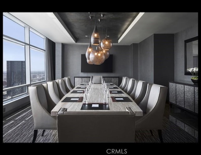 dining space with a chandelier and a raised ceiling