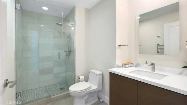 bathroom with a shower with door, vanity, and toilet