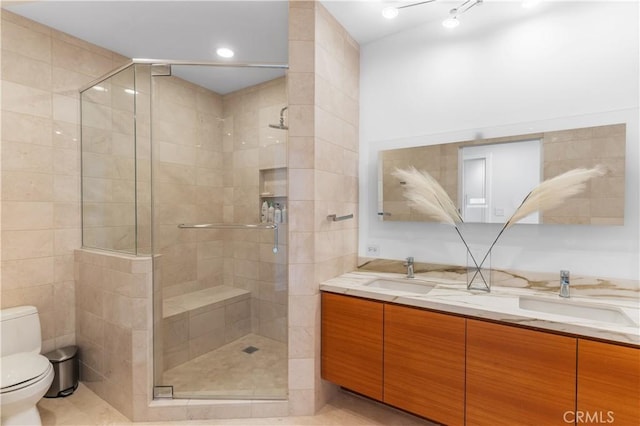 bathroom featuring vanity, a shower with shower door, and toilet