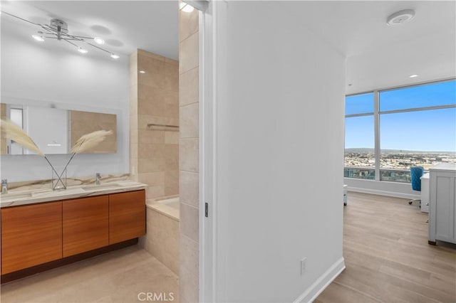 bathroom with vanity, tiled bath, and hardwood / wood-style floors