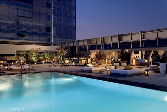 pool at dusk featuring a patio