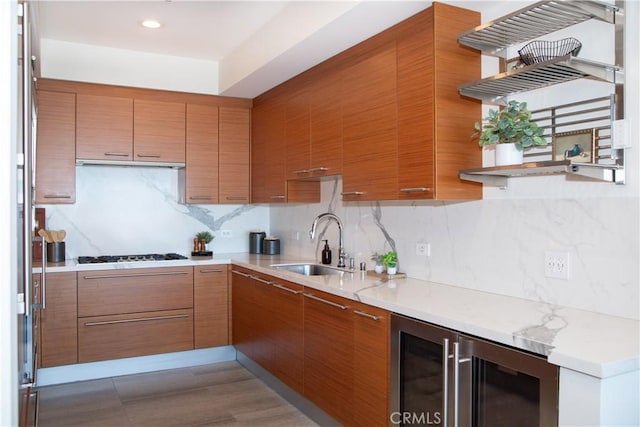kitchen featuring tasteful backsplash, a sink, brown cabinetry, gas cooktop, and wine cooler