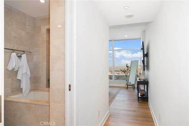 full bath featuring recessed lighting, baseboards, wood finished floors, and tiled shower / bath