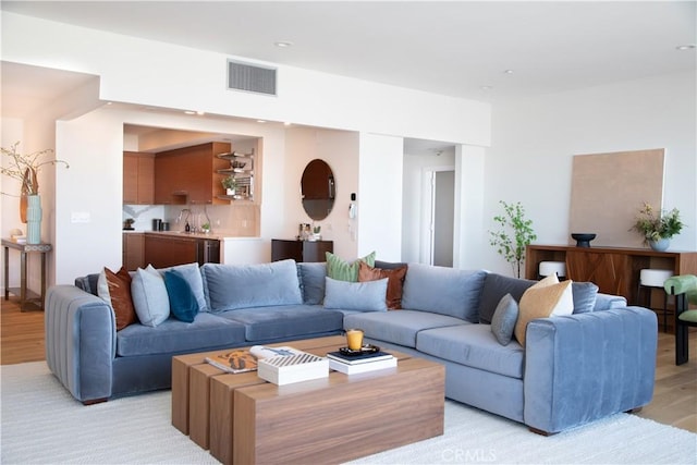living room with light wood-style floors and visible vents