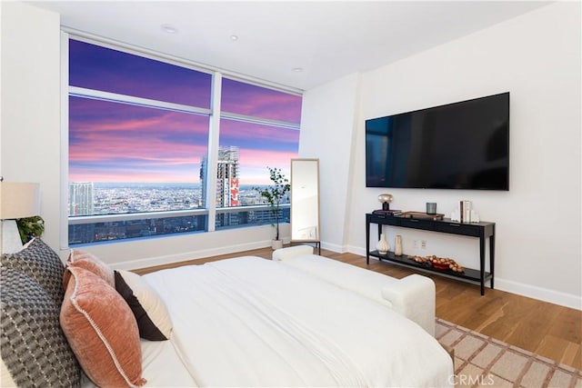 bedroom with baseboards and wood finished floors