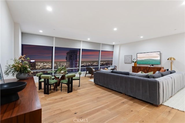 living area featuring a wall of windows, light wood-style flooring, and recessed lighting