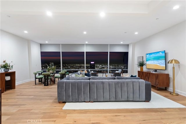 living room with light wood-style flooring, baseboards, and recessed lighting