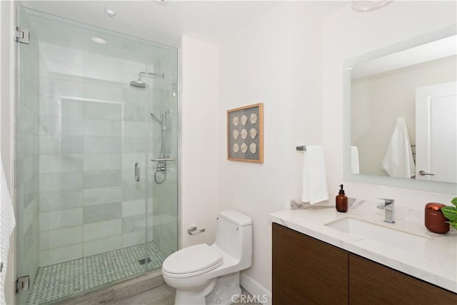bathroom with a shower stall, toilet, and vanity