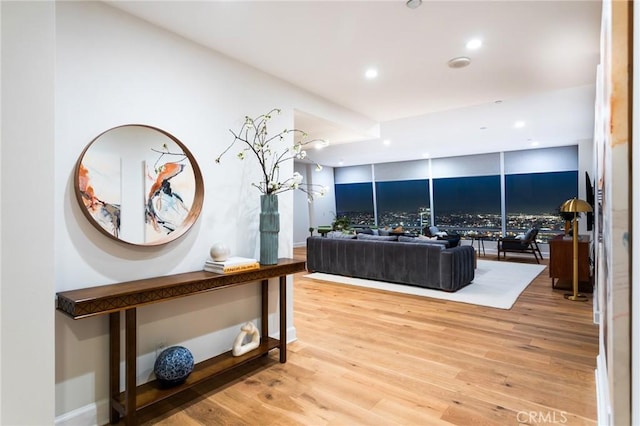 living area featuring baseboards, wood finished floors, and recessed lighting