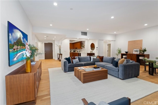 living area featuring light wood-style flooring, visible vents, and recessed lighting