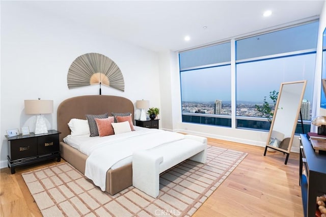 bedroom with recessed lighting, wood finished floors, and baseboards