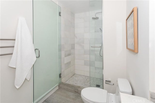 bathroom featuring a shower stall and toilet