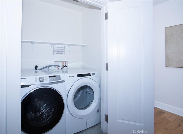 laundry room with washing machine and dryer, light wood-style flooring, baseboards, and laundry area