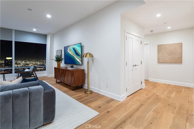living area featuring recessed lighting, baseboards, and light wood-type flooring