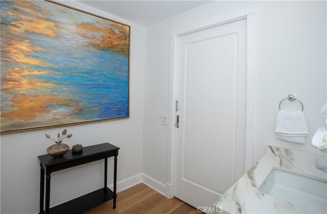 hall featuring baseboards and wood finished floors