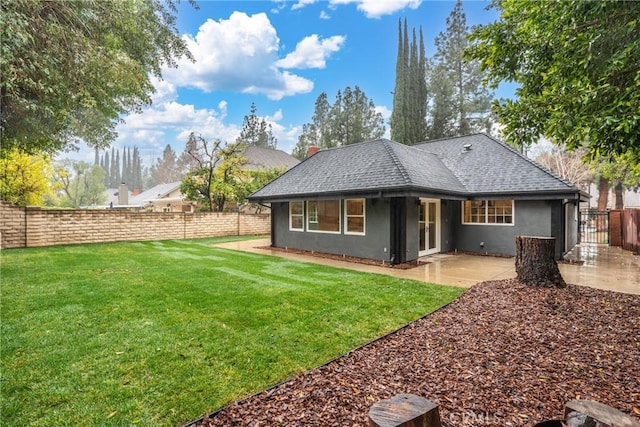 rear view of property with a yard and a patio