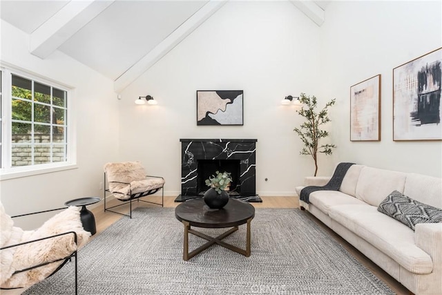 living room with high vaulted ceiling, hardwood / wood-style floors, a fireplace, and beam ceiling