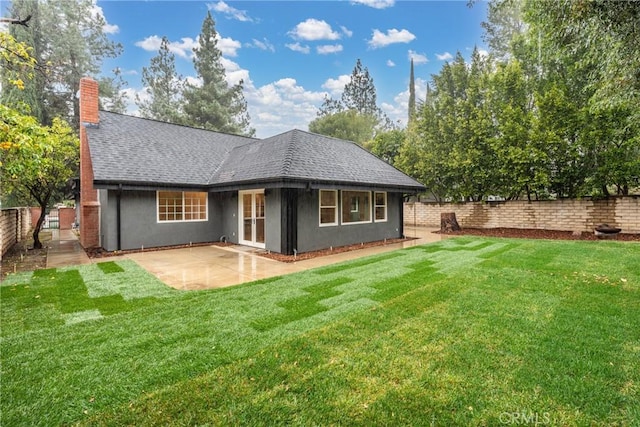 back of house featuring a patio and a lawn