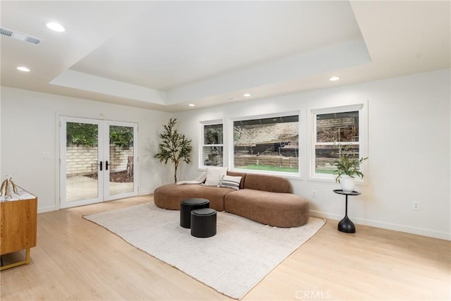 sitting room featuring french doors, a tray ceiling, and a wealth of natural light