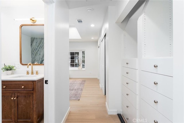 spacious closet featuring sink and light wood-type flooring