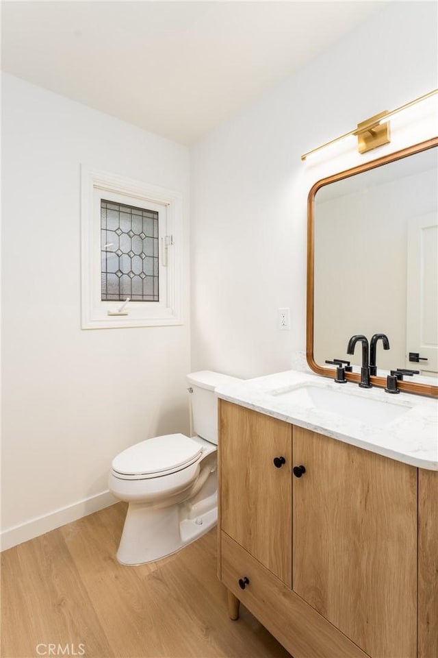 bathroom featuring vanity, toilet, and wood-type flooring