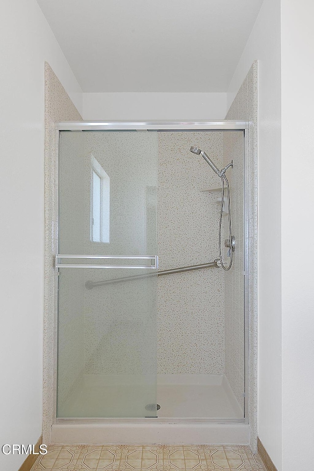 bathroom with a shower with door