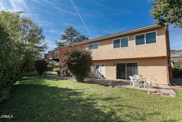 back of property featuring a patio and a yard