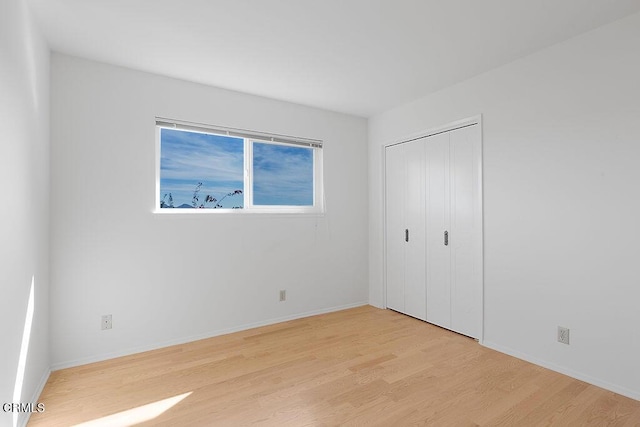 unfurnished bedroom with a closet and light hardwood / wood-style flooring