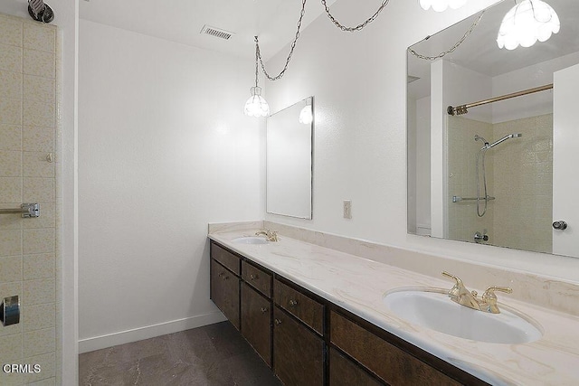 bathroom with vanity and a tile shower