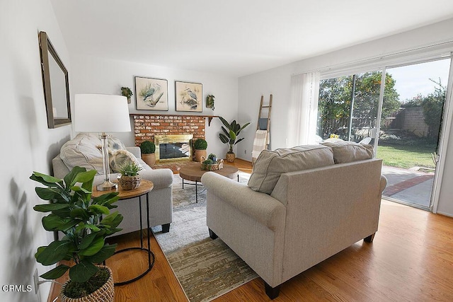 living room featuring hardwood / wood-style flooring and a brick fireplace