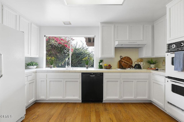 kitchen with white cabinetry, tile countertops, and white appliances