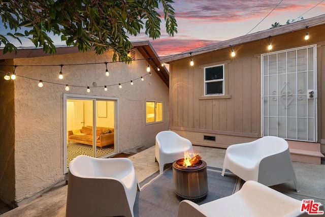 patio terrace at dusk featuring an outdoor fire pit