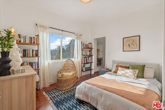 bedroom with dark hardwood / wood-style floors