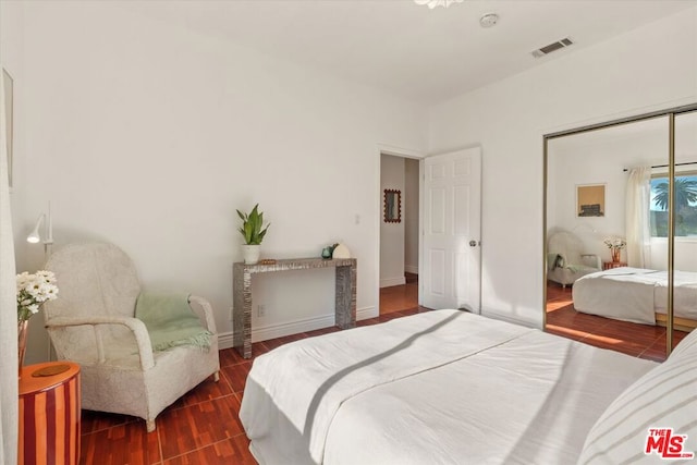 bedroom with dark wood-type flooring and a closet