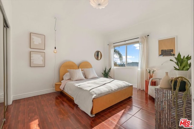 bedroom with dark hardwood / wood-style flooring