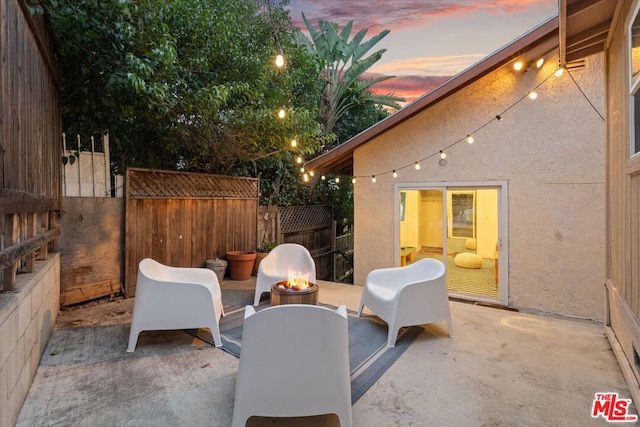 patio terrace at dusk featuring an outdoor fire pit