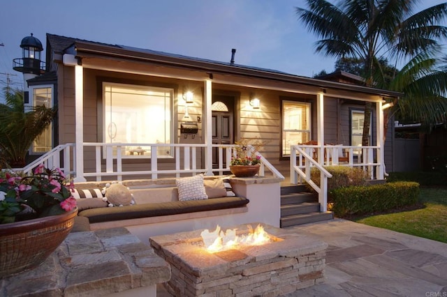 view of front facade featuring a fire pit and covered porch