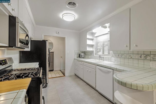 kitchen featuring white cabinetry, sink, tile counters, and stainless steel appliances