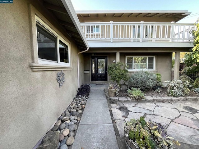 view of exterior entry with a balcony