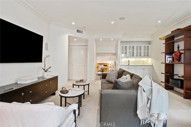 carpeted living room featuring ornamental molding and sink