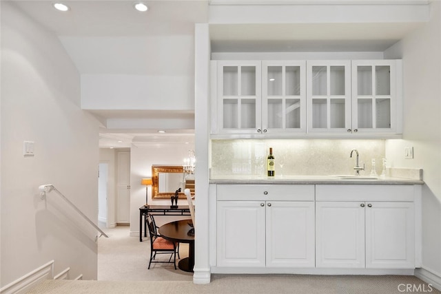 bar with white cabinetry, light carpet, sink, and decorative backsplash