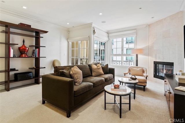 carpeted living room with ornamental molding and a tile fireplace