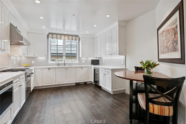 kitchen with dark hardwood / wood-style floors, wall oven, beverage cooler, and white cabinets