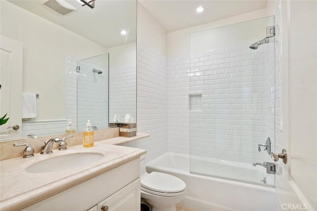 full bathroom featuring tiled shower / bath, vanity, and toilet