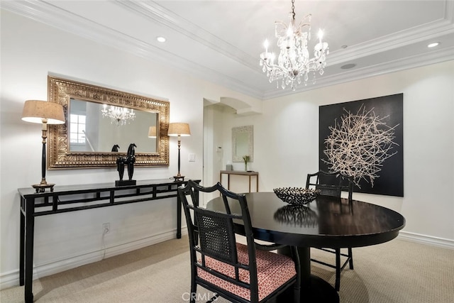 dining room with a chandelier, ornamental molding, a raised ceiling, and light carpet