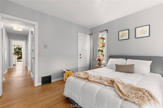 bedroom featuring multiple windows, light wood-type flooring, and a closet