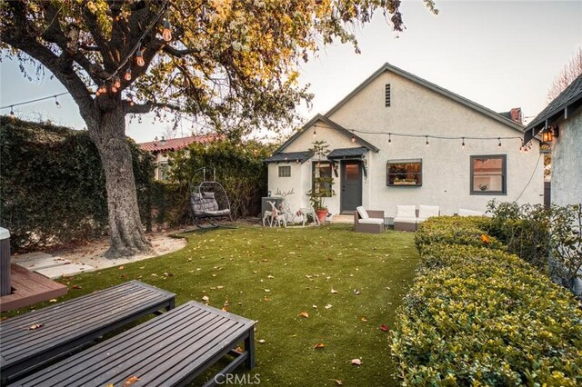 back of house with a yard and an outdoor hangout area