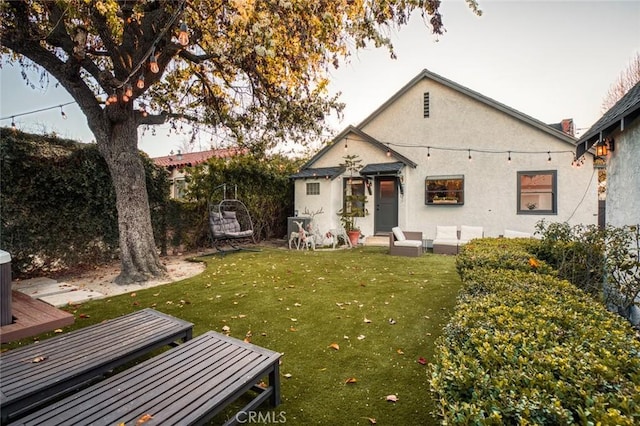 view of front of home featuring fence, a front lawn, and stucco siding